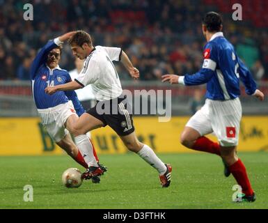 (Dpa) - deutsche Mittelfeldspieler Torsten Frings (C) Kämpfe um den Ball mit Nenad Kovacevic (L) von Serbien-Montenegro während der Teamkapitän Zoran Mirkovic (R) von Serbien-Montenegro schaut die Szene während der freundliche internationale Deutschland gegen Serbien-Montenegro in Bremen, Deutschland, 30. April 2003. Deutschland gewann mit 1: 0 (0: 0). Stockfoto