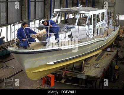 (Dpa) - Bootsbauer arbeiten an einem Polizeiboot in der Schiffswerft von Genthin, Ostdeutschland, 21. Januar 2003. Es ist eines der vier Schiffe gebaut für die Fluss-Polizei am Rhein in Duisburg. Stockfoto