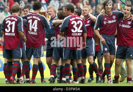 (Dpa) - feiern die Spieler des FC Bayern München nach dem Gewinn der deutschen Meisterschaft nach dem Bundesliga-Spiel gegen den VfL Wolfsburg in Wolfsburg, Deutschland, 26. April 2003. In der Mitte Bayerns Torwart und Team Kapitän Oliver Kahn (blaues Hemd). FC Bayern München waren gekrönte deutsche Bundesliga Champions zum 18. Mal mit vier Spiele zu ihrem 2: 0-Sieg bei folgenden gehen Stockfoto