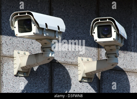 zwei weiße CCTV Überwachungskameras an der Wand Stockfoto