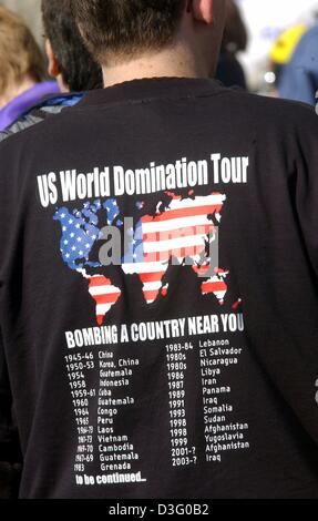 (Dpa) - ein Einwender trägt ein T-shirt, das "Uns World Domination Tour, bombardiert ein Land in Ihrer Nähe" während einer Kundgebung in Essen, Deutschland, 20. April 2003 liest. Dieses Jahr Ostern Rallye im Ruhrgebiet endete mit einem Friedensfest in Dortmund am 21. April. Stockfoto