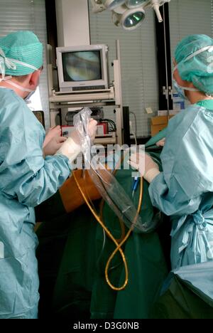 (Dpa) - ein Chirurg und sein Assistent Blick auf dem Monitor während einer Operation am Knie eines Patienten in der Klinik in Iserlohn, Deutschland, 11. März 2003. Das endoskopische Verfahren ermöglicht den Chirurgen, verpflichten sich eine Operation mit minimalem Aufwand, beim Betrachten eines Monitors das Einsatzgebiet anzeigt. Ambulante Chirurgie unter voll- oder lokale Anästhesie ist die Domäne eine Stockfoto