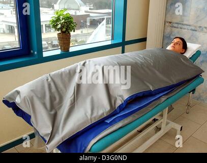 (Dpa) - entspannt eine Frau ruhig unter einer dicken, warmen Decke auf einem Feldbett in der Thalasso-Vital-Center im Hotel Neptun in Warnemünde, Ostdeutschland, 11. Februar 2003.  Das Neptune Hotel ist das einzige Hotel in Deutschland, das die internationalen Kriterien für Thalasso-Zentren erfüllt. Stockfoto