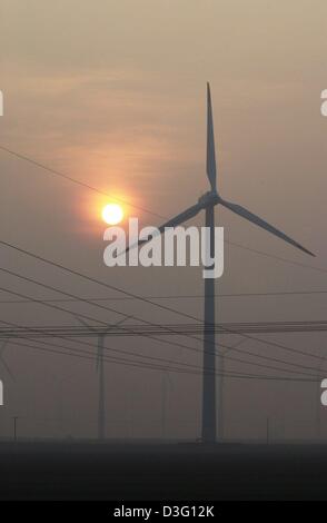 (Dpa) - die Silhouetten der Windmühlen können kaum in das helle Licht der untergehenden Sonne an einem bewölkten Abend in Dithmarschen, Norddeutschland, 28. Februar 2003 gesehen werden. Stockfoto