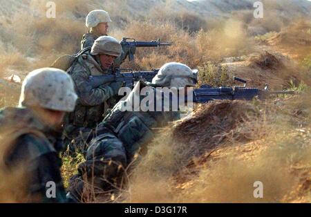 (Dpa) - eine Gruppe von US-Marines des 3. Light Armoured Reconnaissance Bataillons im Kampf, nehmen decken in einem Graben bei einem Angriff von Partisanen zwischen Nasiriya und Bagdad, Irak, 27. März 2003. Der Dpa-Fotograf, der das Bataillon begleitet, berichtet schwere Luftangriffe und Artillerie-Feuer auf irakische Artilleriestellungen in den frühen Morgenstunden am 28. März 2003. Das Bataillon nicht con Stockfoto