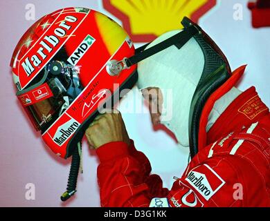 (Dpa) - deutscher Formel-1-Weltmeister Michael Schumacher (Ferrari) setzt seinen Helm an den Ferrari-Grube auf der Formel 1 Rennstrecke nach der Qualifikation für den Formel 1 grand Prix-Rennen in Sepang in der Nähe von Kuala Lumpur, Malaysia, 22. März 2003. Das zweite Rennen der diesjährigen Saison fand am 23. März 2003. Schumacher kam auf Platz sechs. Stockfoto