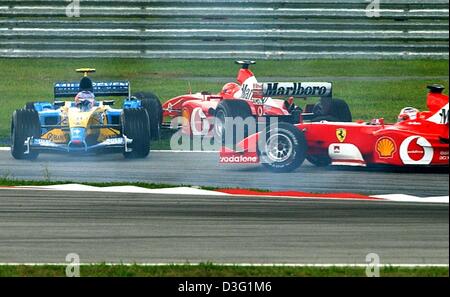 (Dpa) - deutscher Formel-1-Weltmeister Michael Schumacher (Ferrari) fährt gegen italienische Fahrer Jarno Trulli (Renault) (L) in der dritten Kurve nach dem Start auf dem Formel 1 Rennen zu verfolgen, während der Formel 1-grand-Prix-Rennen in Sepang in der Nähe von Kuala Lumpur, Malaysia, 23. März 2003. Italienischer Formel-1-Fahrer Rubens Barrichello (Ferrari) (R) überholt beide Fahrer auf der Rennstrecke. Schu Stockfoto