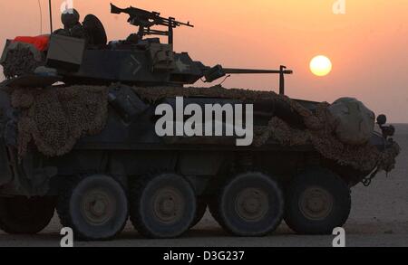 (Dpa) - steht ein leichter LAV Panzer von der 3. Licht Amoured Reconnaissance Battalion (LAR) von der US-Marines Wache im Schein der Wüstensonne in der Abenddämmerung in Kuwait, 17. März 2003. Die Soldaten erwarten die Aufträge für den Einsatz von US-Präsident Bush nach Ablauf des Ultimatums 48 Stunden. Stockfoto