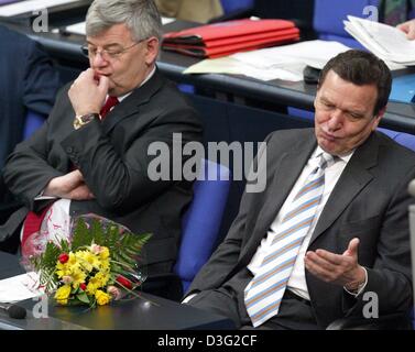(Dpa) - German Chancellor Gerhard Schroeder (R) und Außenminister Joschka Fischer auf ihren Plätzen sitzen, nachdem Schroeders parlamentarische Rede im Bundestag, das Unterhaus des Parlaments, in Berlin, 14. März 2003 sehnsüchtig erwartet. Vor Schroeder liegt einen Blumenstrauß, die er nach seiner Rede von einem Mitglied des Parlaments erhalten hatte. In seiner Rede, die Deutsch-Chancello Stockfoto