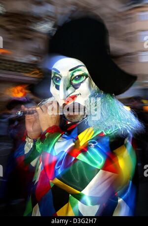 (Dpa) - ein Karneval-Zecher spielt Musik und Spaziergänge durch die Innenstadt von Basel, Schweiz, 10. März 2003. Er ist einer der vielen Menschen in Verkleidung, die die 100.000 Zuschauer zu amüsieren. Diese so genannte "Morgestraich" endet die Saison Spaß und Frivolität. Stockfoto