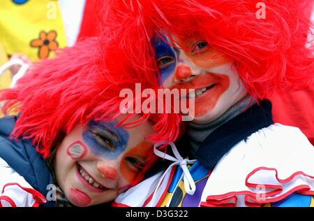 (Dpa) - zwei kleine Clowns sehen die traditionellen Rosenmontag (Karneval Montag) Karnevalszug in Köln, 3. März 2003. Etwa 1,2 Millionen Karneval Narren sind die Parade in Köln besucht. Besonders für Kinder ist die Parade der Höhepunkt des Faschings wenn Süßigkeiten und Plastikspielzeug aus den Wagen in die Menge geworfen werden.