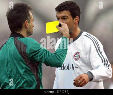 (Dpa) - Bayerns Mittelfeldspieler Michael Ballack (R) sieht gelb während der Fußball-Bundesliga Energie Cottbus gegen Bayern München in Cottbus, Deutschland, 1. März 2003 Spiel. Schiedsrichter Jürgen Aust (L) aus Köln bestraft Ballack für "Gezeter". Tabellenführer FC Bayern München gewinnt das Spiel 2: 0 (1: 0). Stockfoto