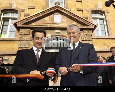 (Dpa) - Französisch Interior Minister Nicolas Sarkozy (L) und sein deutscher Amtskollege Otto Schily Durchschneiden eines Bandes in ihren Ländern Farben bei der Eröffnung eines Zentrums für gemeinsame Polizei in Kehl, Deutschland, 10. Februar 2003. in der ehemaligen Kaserne werden 49 Polizei- und Zollbeamte tätig aus Frankreich und Deutschland zusammenarbeiten. Der Minister sagte, dass beide Länder wie z. B. Maßnahmen würden Stockfoto