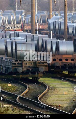 (Dpa) - Güterzüge mit Spulen von Stahlplatten auf dem Gelände der ThyssenKrupp-Stahlwerk in Duisburg-Bruckhausen, Deutschland, 3. Dezember 2003 geladen werden. Im Hintergrund sehen einen alten Förderturm. Stockfoto