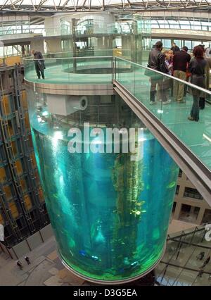 (Dpa) - Besucher auf der Brücke in das "Aquadome" in der Lobby des zukünftigen Radisson SAS Hotel in Berlin, 1. Dezember 2003 stehen. Das Aquadome ist 25 Meter hoch und hat einen Durchmesser von 12 Metern. Im Inneren des Tanks ist ein Aufzug bietet einen Panoramablick über bunte Fischschwärme. Stockfoto