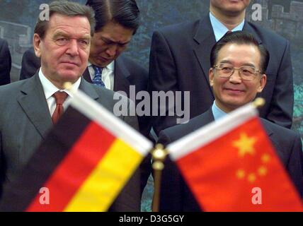 (Dpa) - deutsche Bundeskanzler Gerhard Schröder (L) und der chinesische Ministerpräsident Wen Jiabao sind hinter ihren jeweiligen Nationalflaggen in Peking, China, 1. Dezember 2003 gesehen. Bei seiner Ankunft nahm Schröder an der Eröffnung eines Büros des TUI, einer von Europas größten Touristikunternehmen, die zusammen mit der China Travel Service plant, die zunehmende Reise-Betwe erweitern Stockfoto