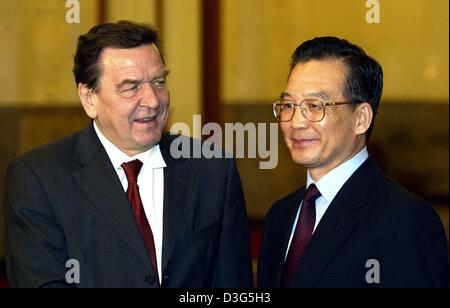 (Dpa) - deutsche Bundeskanzler Gerhard Schröder (L) und der chinesische Ministerpräsident Wen Jiabao sind hinter ihren jeweiligen Nationalflaggen in Peking, China, 1. Dezember 2003 gesehen. Bei seiner Ankunft nahm Schröder an der Eröffnung eines Büros des TUI, einer von Europas größten Touristikunternehmen, die zusammen mit der China Travel Service plant, die zunehmende Reise-Betwe erweitern Stockfoto