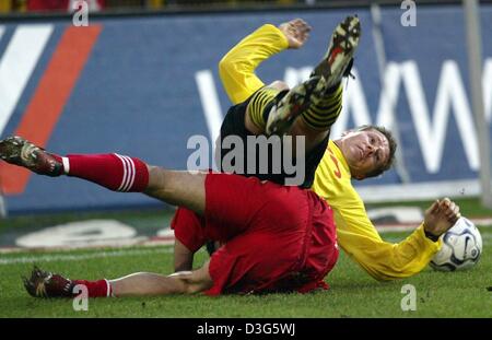 (Dpa) - der Dortmunder Mittelfeldspieler Stefan Reuter (oben) und Leverkusens brasilianische Mittelfeldspieler Robson Ponte beide zu Boden fallen als der Kampf um den Ball während der Fußball-Bundesliga-Spiel Borussia Dortmund gegen Bayer 04 Leverkusen in Dortmund, Deutschland, 22. November 2003. Trotz der Dortmunder 2: 0-Führung das Spiel 2: 2 endete (2: 1) Unentschieden. Stockfoto