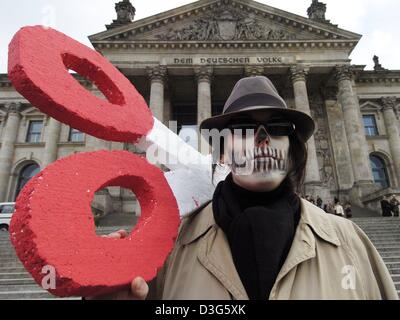 (Dpa) - ein Student, trägt eine Maske, die ähnlich wie ein Schädel trägt ein riesiges Paar Polystyrol Schere auf seinen Schultern bei einem Schüler-Protest vor der Reichstag in Berlin, 24. November 2003. Zahlreiche Schüler streikten und beteiligte sich an verschiedenen Veranstaltungen um ihren Protest gegen die Sparpakete der Stadt Berlin im Bereich der Bildung und höhere Educat markieren Stockfoto