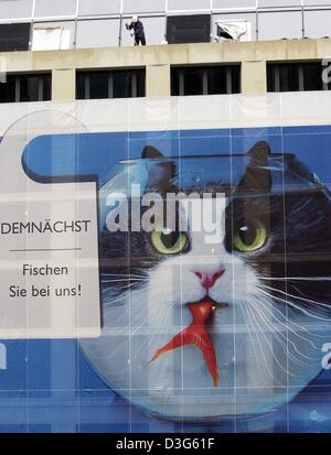 (Dpa) - eine Katze sitzt in einem Glas und verschlingt einen Fisch ist eine Anzeige des neuen Hotels und shopping Komplex "DomAquarée" in Berlin, 19. November 2003. Die Hauptattraktion des Komplexes befindet sich gegenüber des Berliner Doms werden 14 m hohen Aquarium mit Meerwasser gefüllt. Der Text auf der linken Seite liest, "Bald - Sie Fischen bei uns". Stockfoto