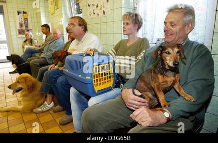 (Dpa) - Haustier-Besitzer und ihre Haustiere im Wartezimmer sitzen und warten, bis die Reihe an die Tierklinik in Magdeburg, Deutschland, 30. September 2003. Das Krankenhaus besteht seit 1971 und beschäftigt 18 Mitarbeiter, davon sind acht Tierärzte. Alle Arten von Tieren werden von kleinen Mäusen zu ausgewachsenen Löwen im Krankenhaus behandelt. Allerdings sind die meisten Tiere Haustiere wie Hunde, Katzen ein Stockfoto