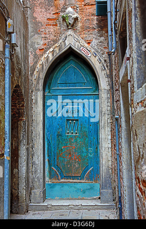 Alte blaue Tür in einer Steinmauer in Venedig, Italien Stockfoto