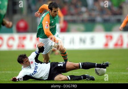 (Dpa) - der Frankfurter Team-Kapitän Alexander Schur Angriffe Bremens französische Mittelfeldspieler Johan Micoud (oben) mit einem Zweikampf während der Bundesliga-Fußball-Spiel SV Werder Bremen gegen Eintracht Frankfurt in Bremen, Deutschland, 1. November 2003. Bremen gewann das Spiel 3: 1 gegen Frankfurt und zählt derzeit Dritte auf der deutschen Rangliste. Stockfoto