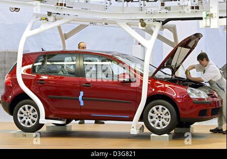 (Dpa) - arbeiten zwei Mitarbeiter von VW auf einen VW Golf V auf der Produktionslinie im Montagewerk für VW in Wolfsburg, Deutschland, 25. August 2003. Das Unternehmen ist aufgrund stagnierender Produktion und einen schwachen Dollar kämpfen.  Der Umsatz sank um 1,8 Prozent auf 64,1 Mrd. Euro am Ende September 2003. VW kündigte an, dass der Vorsteuergewinn um 53,4 Prozent auf 64,1 Mrd. Euro sackte Stockfoto