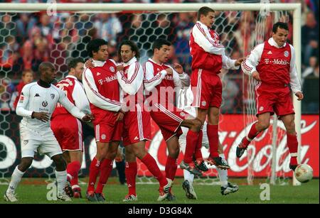 (Dpa) - die Mauer der Bayern-Spieler (von R:) Parieren Sie Jens Jeremies, Sebastian Deisler, Roy Makaay, Claudio Pizarro und Michael Ballack, einen Freistoß, während der Bundesliga-Fußballspiel des FC Bayern München gegen FC Kaiserslautern in München, 25. Oktober 2003. Bayern Verteidiger Thomas Linke (2. v. L) und Kaiserslautern Verteidiger Bill Tchato aus Kamerun (L) beobachten die Szene. B Stockfoto