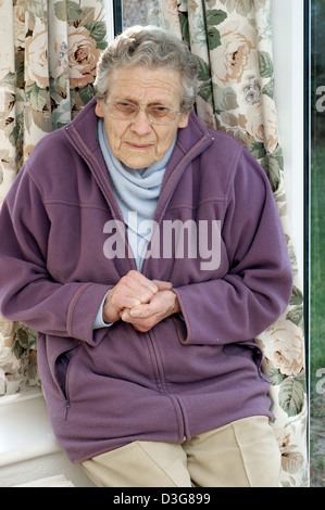 Ältere Frau trägt eine Fleece-Jacke & einen warmen Schal versucht, bei kaltem Wetter warm zu halten Stockfoto