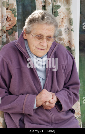 Ältere Frau trägt eine Fleece-Jacke & einen warmen Schal versucht, bei kaltem Wetter warm zu halten Stockfoto