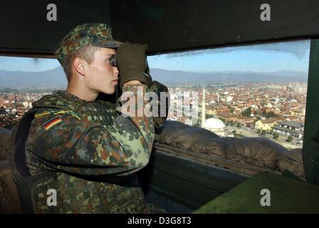 (Dpa) - überblickt die Stadt von Prizren, Kosovo, 11. Oktober 2003 ein deutsches Soldaten der internationalen Friedenstruppe KFOR in einem Wachturm mit einem Fernglas. Laut der deutschen Verteidigung sind derzeit Ministerium 8.500 Bundeswehrsoldaten im Ausland eingesetzt. Deutsche Truppen im Kosovo (KFOR), in Bosnien-Herzegowina (SFOR), in Mazedonien (Concordia), stationiert in Afghanistan (ISAF), Uz Stockfoto