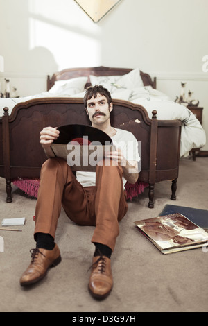 Retro-Hipster Mann Musikhören LP Vinyl Records zu Hause Stockfoto