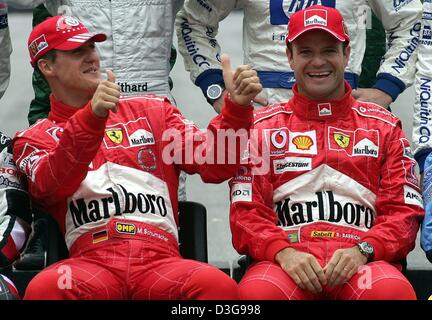 (Dpa) - Ferrari deutscher Formel-1-Weltmeister Michael Schumacher (L) und sein brasilianischer Teamkollege Rubens Barrichello teilen sich einen hellen Moment als Formel1 Fahrer für Fotografen vor Beginn der brasilianischen Formel Eins Grand Prix auf der Rennstrecke Interlagos in Sao Paulo, Brasilien, Sonntag, 24. Oktober 2004 darstellen. Stockfoto