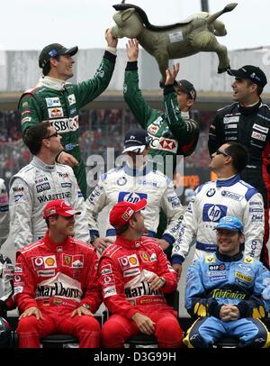 (Dpa) - Formel-1-Rennfahrer Mark Webber, Christian Klien (beide Jaguar), Zsolt Baumgartner (Minardi, hintere Reihe L-R), David Coulthard (McLaren Mercedes), Ralf Schumacher, Montoya (beide BMW-Williams, mittlere Reihe L-R), Michael Schumacher, Rubens Barrichello (beide Ferrari) und Jacques Villeneuve (Renault, vordere Reihe L-R) mit einem aufblasbaren Esel aus "Shrek" Mov Herumspielen Stockfoto