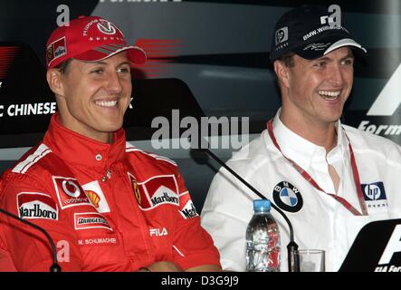 (Dpa) - deutsche Formel-1-Fahrer Michael Schumacher (L, Team Ferrari) und seinem Bruder Ralf Schumacher (R, Team BMW-Williams) Lächeln, während einer Pressekonferenz auf dem neuen Shanghai International Circuit in Shanghai, China, 24. September 2004. Die chinesischen Grand Prix, das erste jemals Formel 1 Rennen auf chinesischem Boden, wird am Sonntag, 26. September 2004 stattfinden. Stockfoto