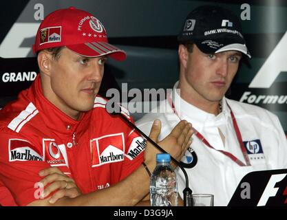 (Dpa) - deutsche Formel-1-Fahrer Michael Schumacher (L, Team Ferrari) und sein Bruder Ralf Schumacher (R, Team BMW-Williams) sitzen nebeneinander, während einer Pressekonferenz auf dem neuen Shanghai International Circuit in Shanghai, China, 24. September 2004. Die chinesischen Grand Prix, das erste jemals Formel 1 Rennen auf chinesischem Boden, wird am Sonntag, 26. September 2004 stattfinden. Stockfoto