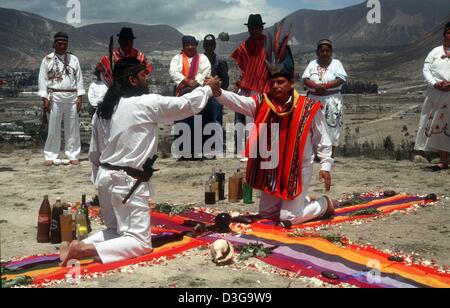 (Dpa-Dateien) - führen zwei Heiler ein Ritual während Schamanen und Medizinmänner stehend in einem halben Blick auf, auf die Inka-Ruine Rumicucho, Ecuadors, 21. März 2002 umrunden. Die Highland Schamanen versammelten sich in den Ruinen, die sich nahe dem Äquator befinden, wie die Sonne genau im Zenit am Mittag an diesem Tag war. Dies bedeutet, dass es keinen Schatten zu Mittag und am Tag so lang wie die Nacht ist. Stockfoto