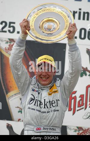 (Dpa) - britische Mercedes-pilot Gary Paffett jubelt da er die Trophäe bei der Preisverleihung in Nürnberg, 27. Juni 2004 hebt. 22-j hrige Paffett geschafft, sich im fünften Rennen der German Touringcar Masters-Meisterschaft (DTM) durchsetzen und gewann auf der 2.300 km langen Strecke nach 72 Runden mit einer Zeit von 1.00.52,341 Stunden. Stockfoto