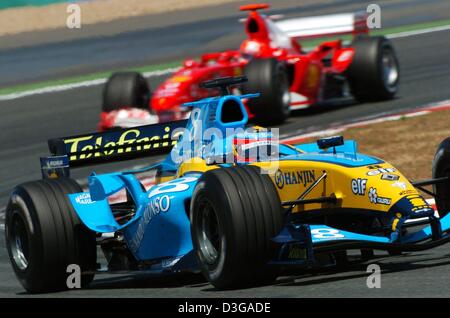 (Dpa) - spanische Formel 1 Piloten Fernando Alonso (Renault) übernimmt die Führung vor Deutschlands Michael Schumacher (Ferrari), während der Grand Prix von Frankreich auf der Rennstrecke in Frankreich, 4. Juli 2004 Magny-Cours. Schumacher gewinnt am Ende das Rennen mit Alonso zweite stattfindet. Stockfoto