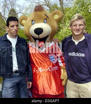 (Dpa) - "Berni", das neue Maskottchen des Fußball-Bundesligisten FC Bayern München, stellt zusammen mit Bayerns-Spieler Roy Makaay (L) und Bastian Schweinsteiger (R) für ein Gruppenbild während einer Präsentation zu Tierpark Hellabrunn in München, Deutschland, Montag, 3. Mai 2004. "Berni" wird offiziell der Verein ehemaliger Maskottchen "Bazi" kurz vor dem Start des Bundes ersetzen Stockfoto