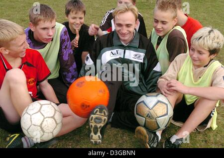 (Dpa) - übt Fußball Trainer Geza Repasi (C) lachend Ausgleich den Ball am Fuß mit Fußball begeistert Jungs des Sports club Merseburg 99 in Merseburg, Deutschland, 29. Oktober 2004. Der 30-Year-Old Regionalgeld Mann ist jetzt wegen einem ungewöhnlichen ein-Euro-Job als Fußball-Trainer für die C2-Gruppe und als Platzwart in dieser Stadt im deutschen Bundesland Sachsen-Anhalt und damit Hav arbeiten Stockfoto