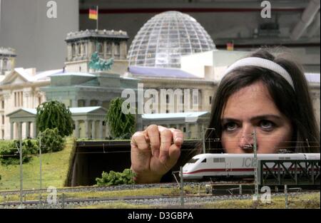 (Dpa) - Modellbauer Sylvia Menelao prüft die Oberleitung nahe dem Reichstag und dem Brandenburger Tor auf Deutschlands größtem betrieben Digital Modelleisenbahn in einem Einkaufszentrum in der Nähe von Bahnhof Zoo in Berlin, Deutschland, 15. September 2004. Brüder Stefan und Henrik Goeddeke fast 3 Millionen Euro in die Modellversion der deutschen Hauptstadt investiert haben und sind aufzuwärmende Stockfoto