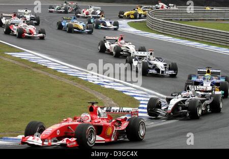 (Dpa) - brasilianische Formel-1-Pilot Rubens Barrichello (vorne) von Ferrari führt die Packung zu Beginn der brasilianischen Formel Eins Grand Prix auf der Rennstrecke Interlagos in Sao Paulo, Brasilien, 24. Oktober 2004. Stockfoto