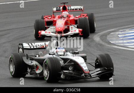 (Dpa) - finnische Formel-1-Pilot Kimi Raeikkoenen (vorne) von McLaren Mercedes ist gefolgt von brasilianischen Ferrari-Fahrer Rubens Barrichello in der brasilianischen Formel Eins Grand Prix auf der Rennstrecke Interlagos in Sao Paulo, Brasilien, 24. Oktober 2004. Stockfoto