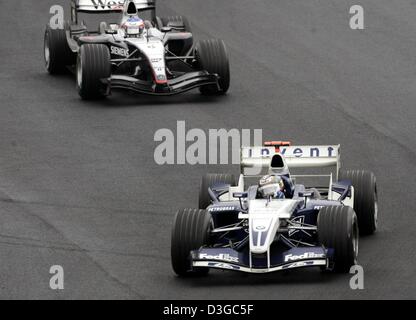 (Dpa) - kolumbianischer Formel1-Fahrer Montoya (vorne) von BMW-Williams ist gefolgt von finnischen Kimi Raeikkoenen von McLaren-Mercedes in der brasilianischen Formel Eins Grand Prix auf der Rennstrecke Interlagos in Sao Paulo, Brasilien, 24. Oktober 2004. Stockfoto