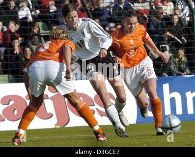 (Dpa) - deutscher Fußballspieler Kerstin Garefrekes (C) wetteifert um den Ball mit niederländischen Gegnerinnen Lisbeth Michelsen (L) und Petra Hogewoning während der internationalen Freundschaftsspiel zwischen Deutschland und den Niederlanden im Ludwig-Jahn-Stadium in Berlin, Deutschland, Donnerstag, 14. Oktober 2004. Stockfoto