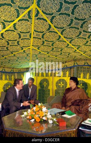 (Dpa) - deutsche Bundeskanzler Gerhard Schröder (L) führt Gespräche mit Gaddafi Muammar Gaddafi (R) in einem traditionellen Zelt in Tripolis, Libyen, Donnerstag, 14. Oktober 2004. Der Mann in der Mitte ist ein Übersetzer. Schröder kam hier Donnerstagabend zum Auftakt seiner ersten zweitägigen Besuch nach Libyen, die erste jemals von einem deutschen Führer in 25 Jahren. Auf politischer Ebene, Beamte in Berlin sai Stockfoto