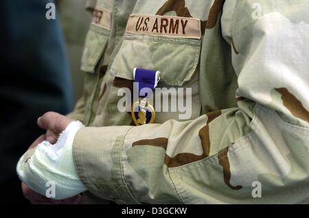 (Dpa) - nach der Rückkehr aus dem Irak, steht ein verletzter US-Soldaten der 1. Panzerdivision, die tragen ein Purple Heart ausgezeichnet an einem Armeestützpunkt in Wiesbaden, Deutschland, 7. Oktober 2004. Stockfoto