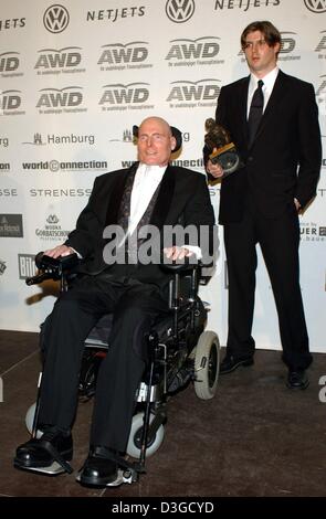 (Dpa-Dateien) - US-Schauspieler Christopher Reeve in seinem Rollstuhl hinter ihm sitzt steht sein Sohn Matthew hält den "Lifetime Achievement Award", die sein Vater, während der Zeremonie der World Awards in Hamburg, Deutschland, 22. Oktober 2003 erhalten. Christopher Reeve, der Schauspieler, der als der-Comic-Helden Superman vor einem Unfall zu internationalem Ruhm katapultiert machte ihn eine Real-life Stockfoto